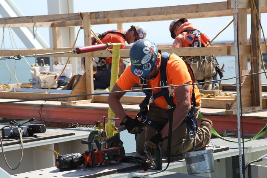 Two ironworkers bolting steel on a bridge deck